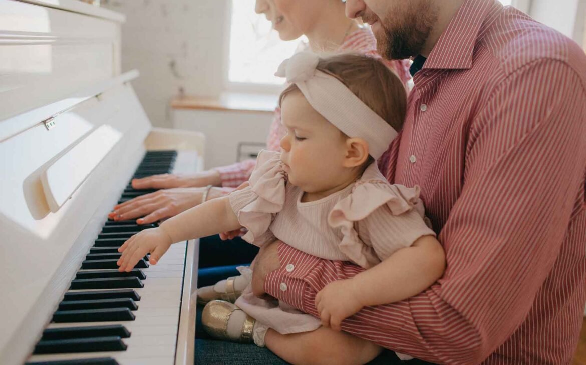 Petite fille bébé qui joue piano avec ses parents