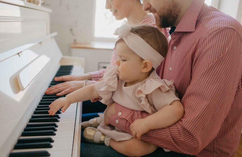 Petite fille bébé qui joue piano avec ses parents